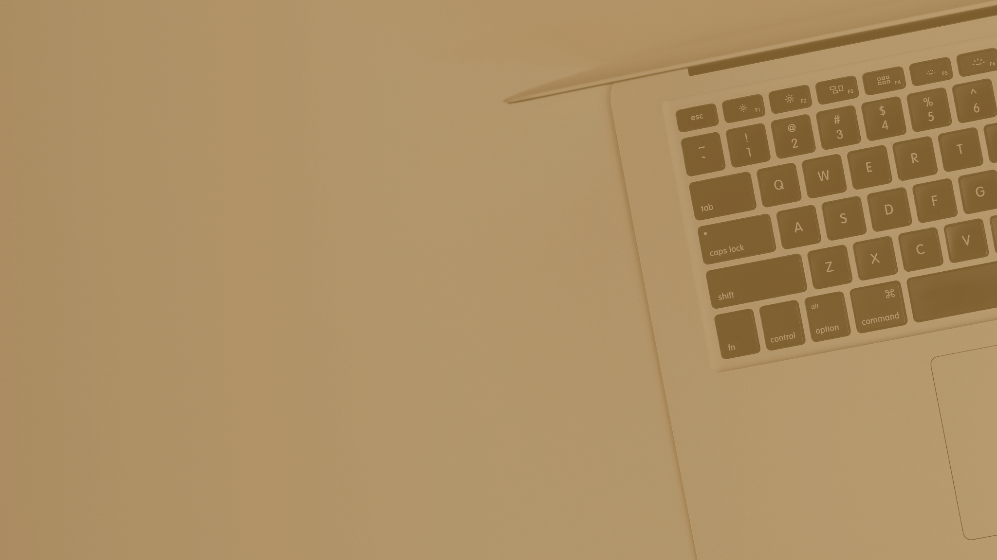 A monochrome sepia tone image of an open laptop on a flat surface, highlighting the keyboard and trackpad, evoking a minimalist and contemporary vibe.